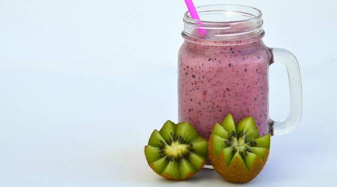 Juice smoothie with two open kiwis against the glass. One wall of her new NY Chelsea location is a vitality bar lined with tonics and juice blends.